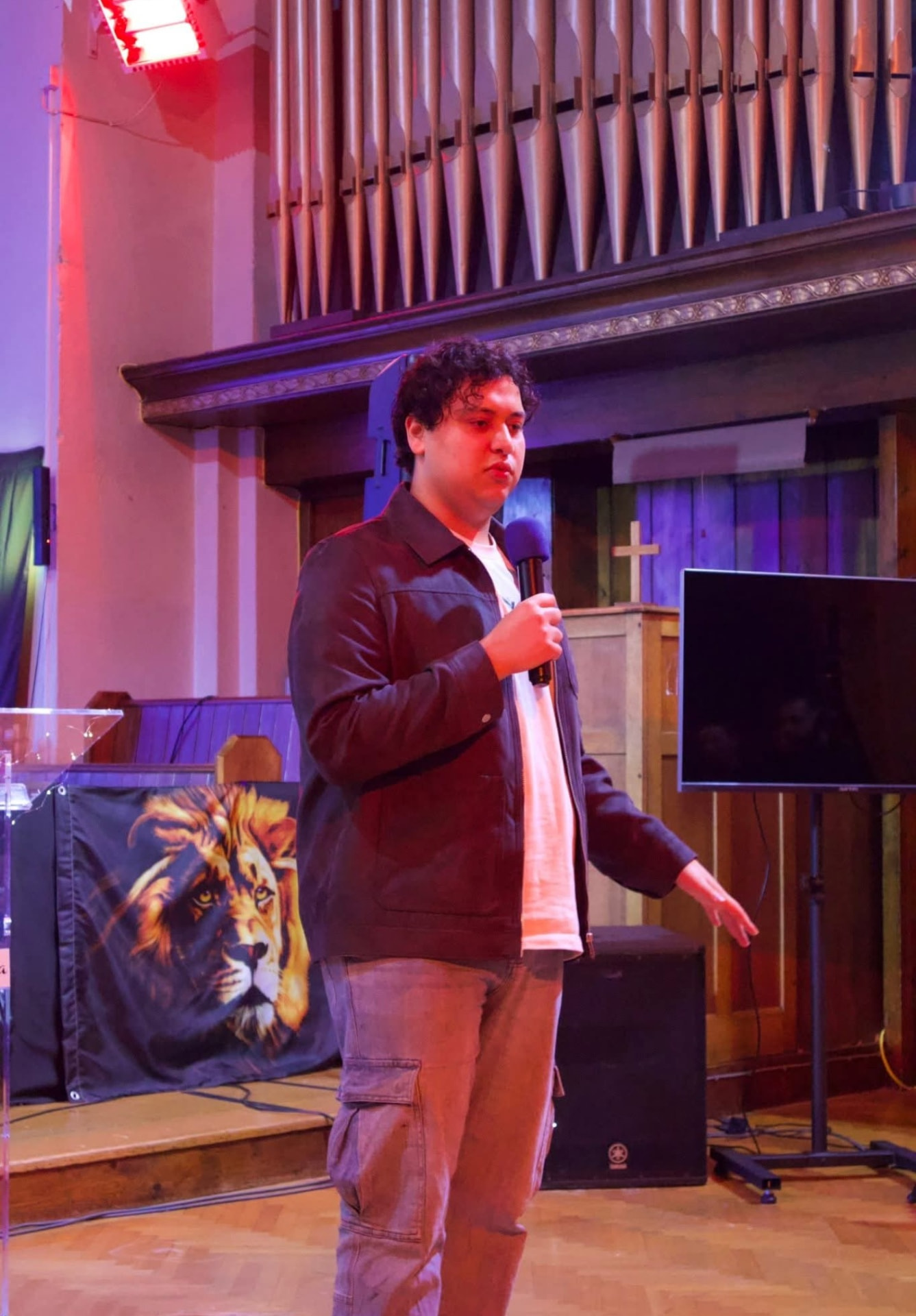 Samuels speaking on stage with a microphone
