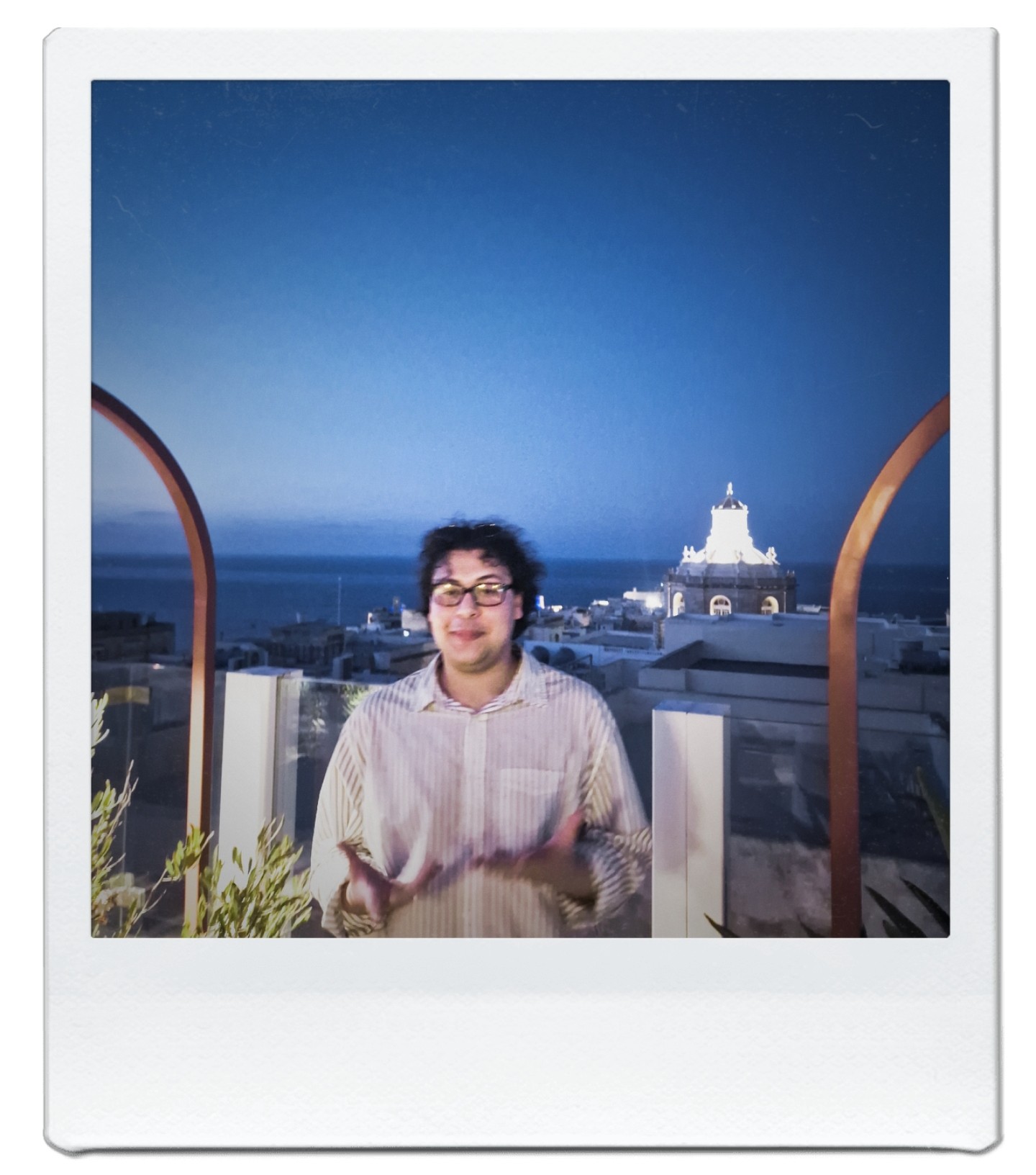 Polaroid of Samuels on a balcony in Malta at dusk