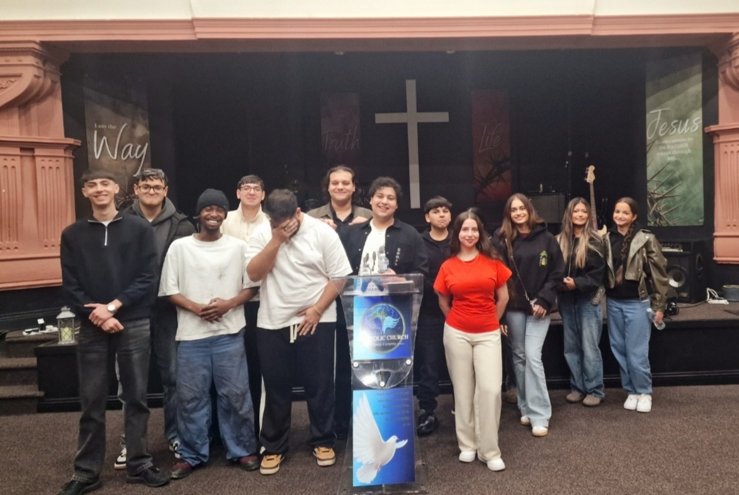 Youth group posing on stage with Samuels in the middle