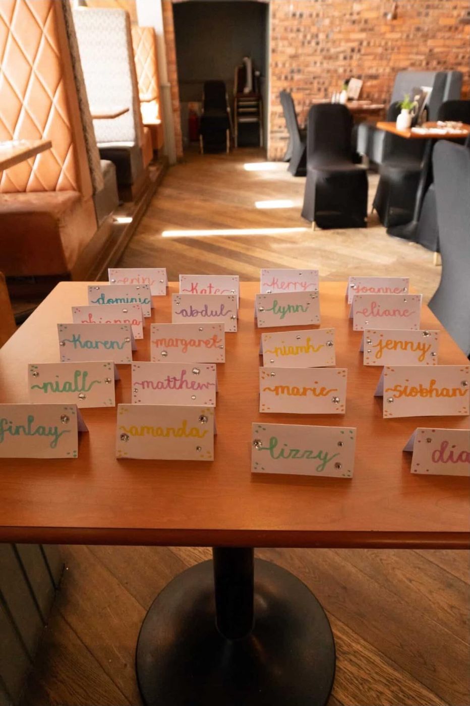 Hand-lettered colourful name cards on a table